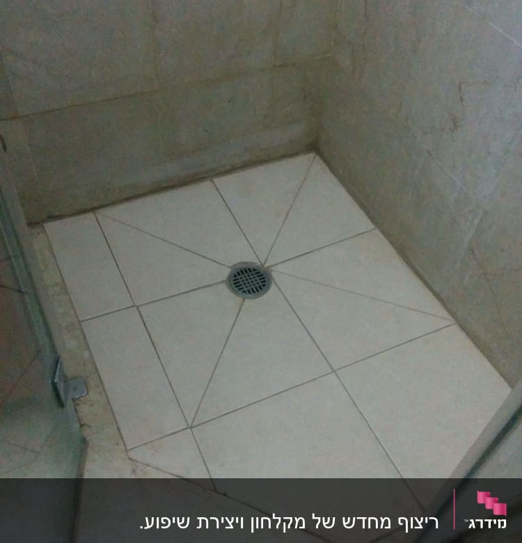 רצפת מקלחת מרוצפת עם ניקוז במרכז